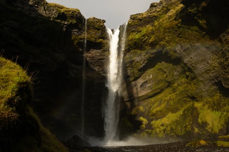 The thin waterfall of Kvernufoss nestled inside of a canyon